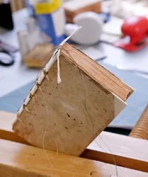Une des nombreuses étapes de la préparation du livre sur l'établi de l'atelier de reliure (cliché Marie-Lan Nguyen).